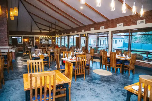 Dining hall with wooden tables under pendant lights and a high timber roof