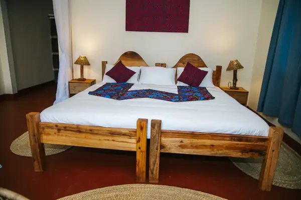 Double room with a king-size bed, bedside lamps and red cushions
