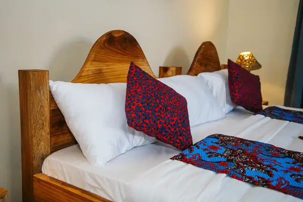 Carved headboard and kitenge cushions