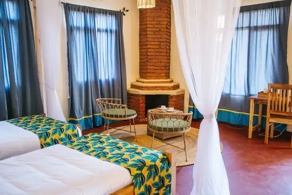Room with two beds and a fireplace