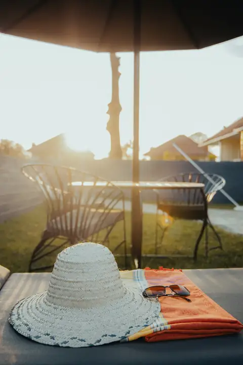 Sun hat on a lounger by the pool at sunset